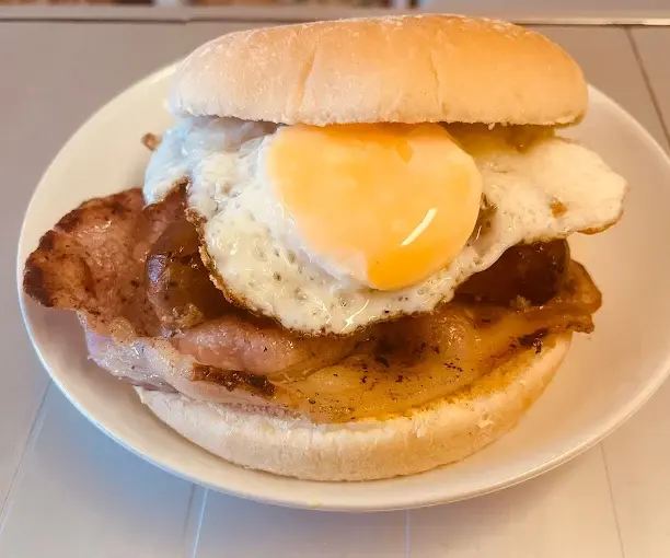 Breakfast bap with fried egg, back bacon and sausage