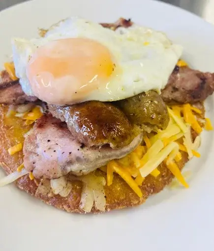 Hash brown stack with sausage, bacon, cheese and fried egg